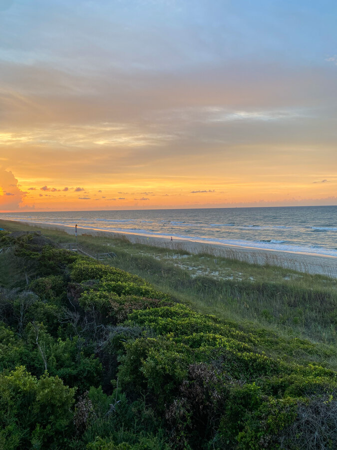 Golden sunset over the ocean and dune grass from the maritime forest at Pine Knoll Shores